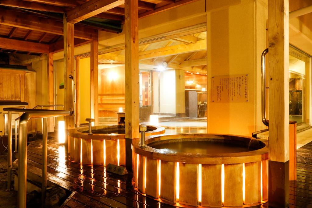 une grande chambre avec deux bains à remous. dans l'établissement Sun Urashima Yuki no Sato, à Toba