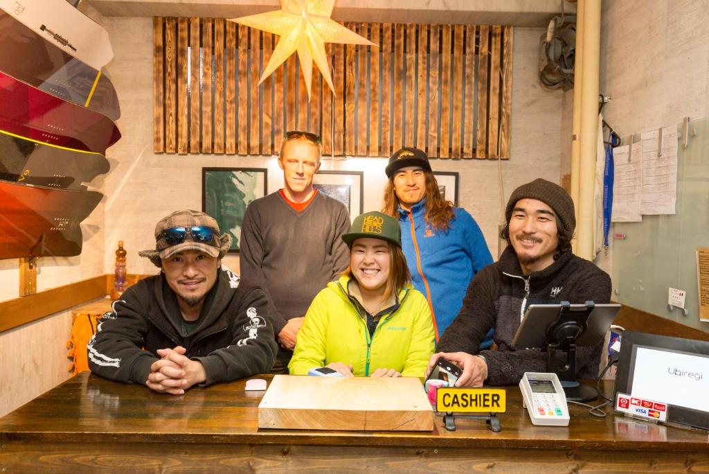 un groupe de personnes debout autour d'une table dans l'établissement Shirakaba, à Nozawa Onsen