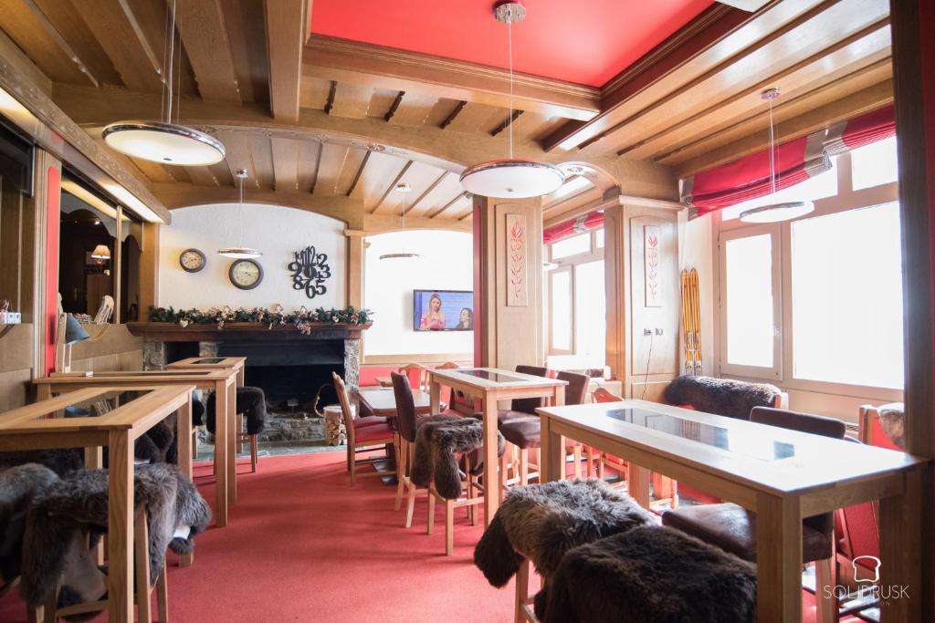 une salle à manger avec tables et chaises et une cheminée dans l'établissement Hotel Le Druos, à Isola 2000
