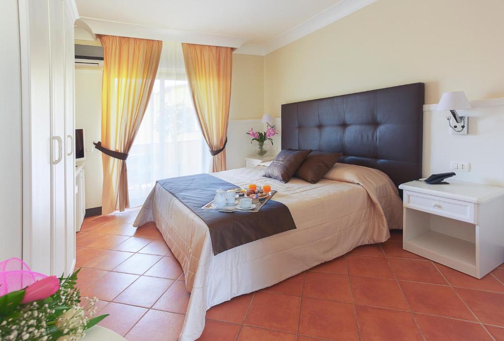 une chambre avec un grand lit avec un plateau de fruits dessus dans l'établissement Baia Di Ulisse Wellness & Spa, à San Leone 91 autres photos