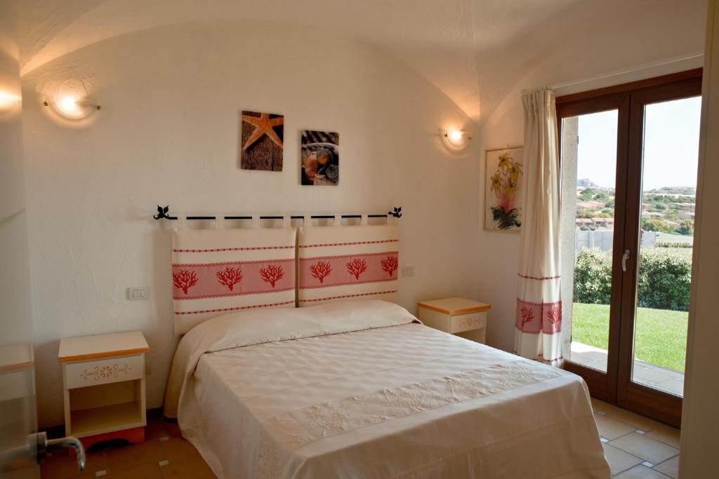 une chambre avec un lit et une grande fenêtre dans l'établissement Le Ville Le Saline, à Palau