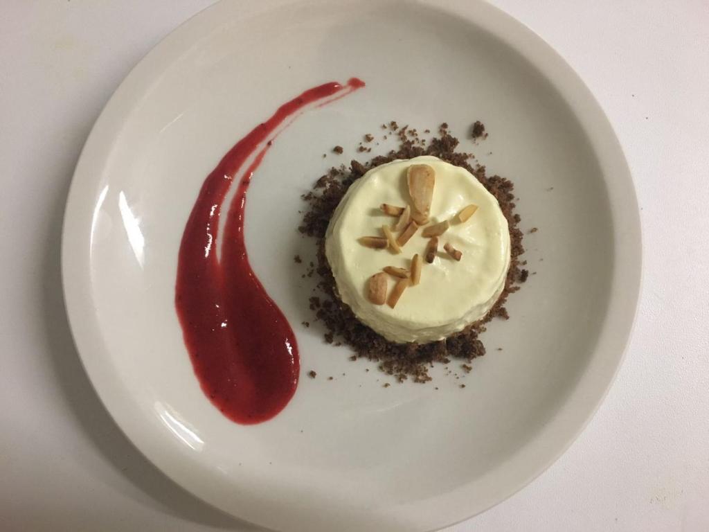 une assiette blanche avec un dessert à la sauce rouge dans l'établissement Hotel Villa Itala, à Rimini