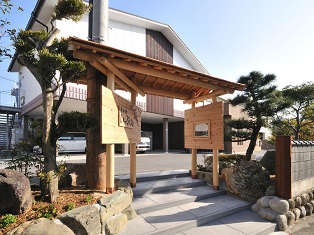 un bâtiment en bois avec un panneau devant un bâtiment dans l'établissement Hanano Koyado Jyu-bei, à Toba