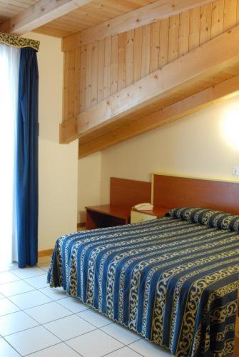 - une chambre avec un lit doté d'une couverture bleue dans l'établissement Hotel Lido, à Lido di Jesolo