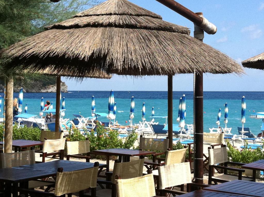 - une plage avec des tables, des chaises, des parasols et l'océan dans l'établissement Best Western Hotel Acqua Novella, à Spotorno