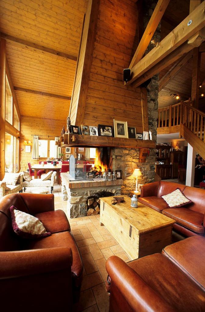 - un salon avec des canapés et une cheminée en pierre dans l'établissement Hôtel et Chalet Au Coin Du Feu Chilly Powder, à Morzine
