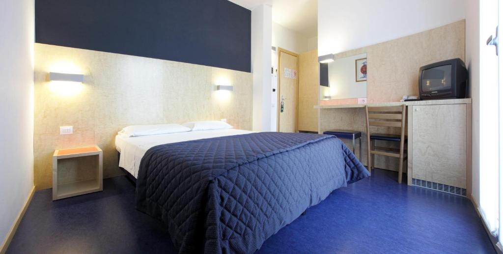 une chambre d'hôtel avec un lit et une télévision dans l'établissement Hotel Firenze, à Bibione