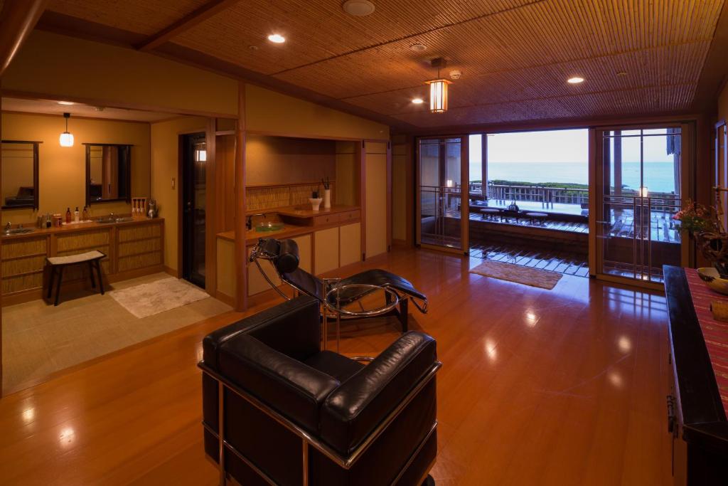 un salon avec un canapé en cuir et une cuisine dans l'établissement Bousui, à Higashiizu