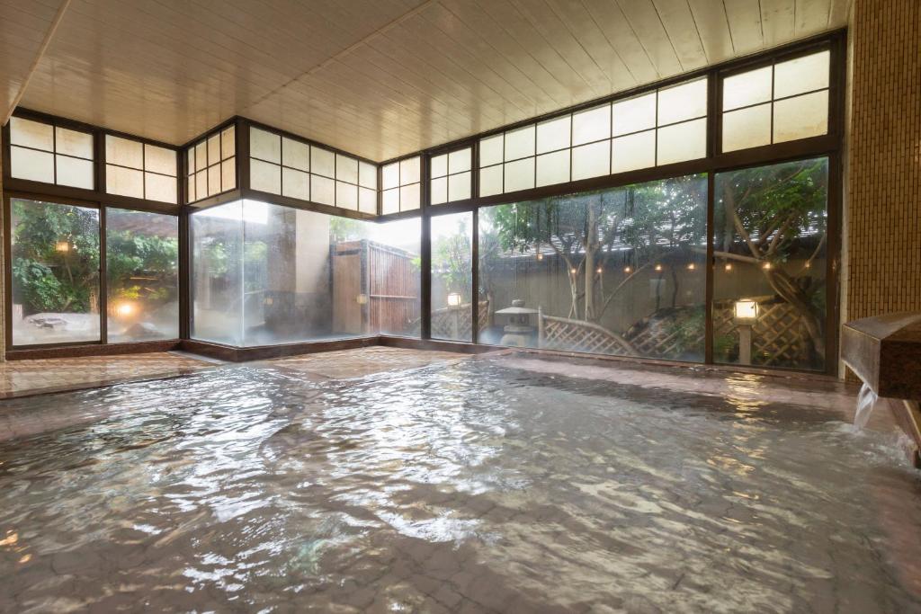 Cette grande chambre dispose d'une piscine avec fenêtres. dans l'établissement Bousui, à Higashiizu