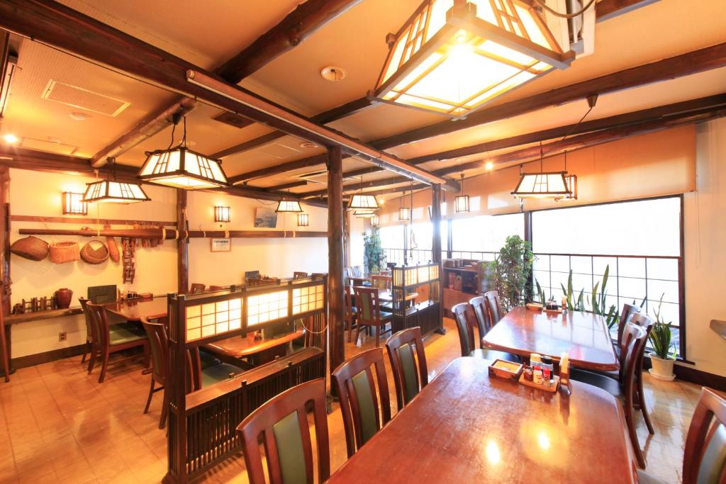 une salle à manger avec des tables, des chaises et des lumières dans l'établissement Fuji Green Hotel, à Fuji
