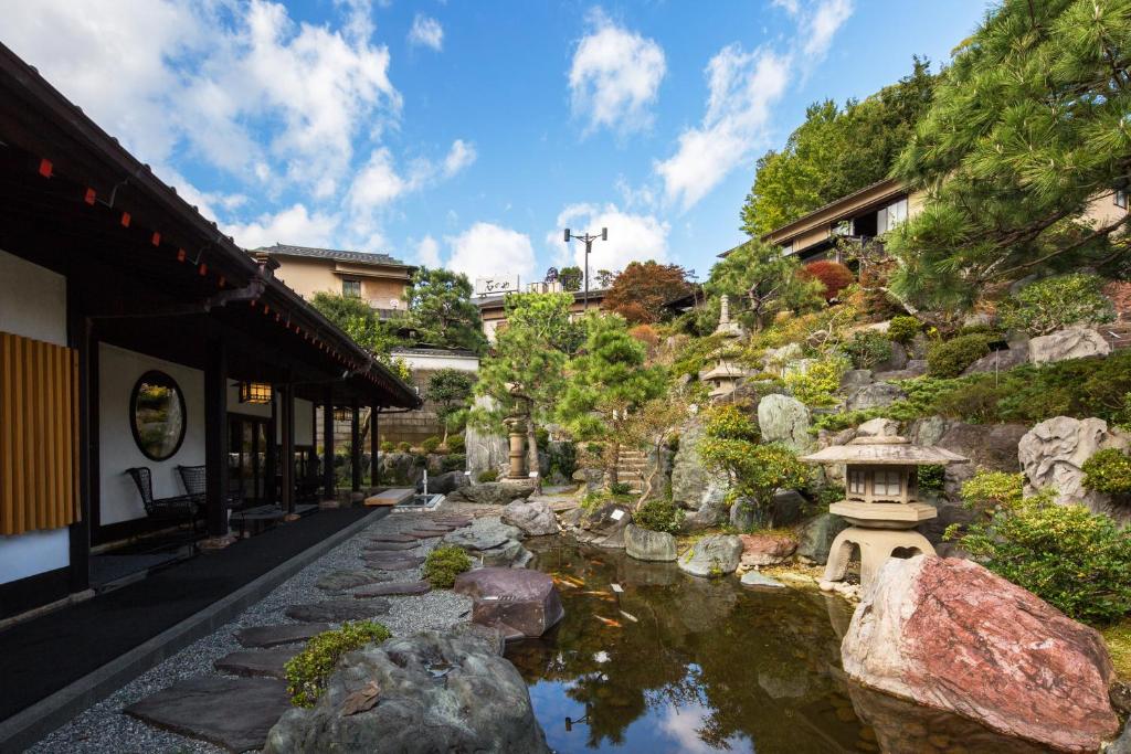 un jardin avec un étang en face d'un bâtiment dans l'établissement Ishinoya Izunagaoka - TKP Hotels & Resorts, à Izunokuni