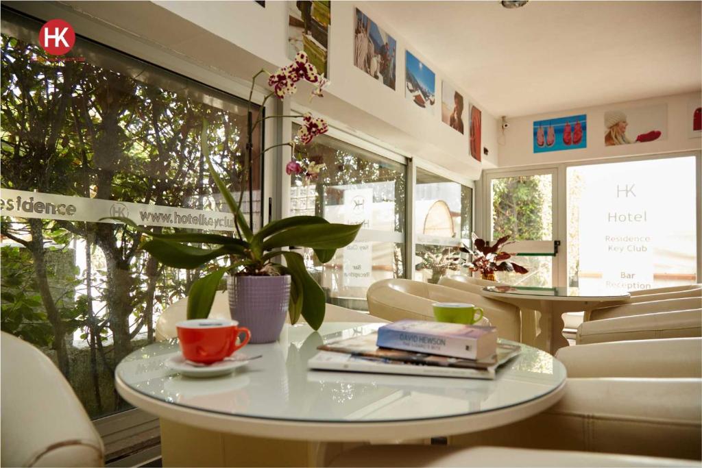 un café avec deux tables et une plante en pot dans l'établissement Hotel Residence Key Club, à Montalto di Castro