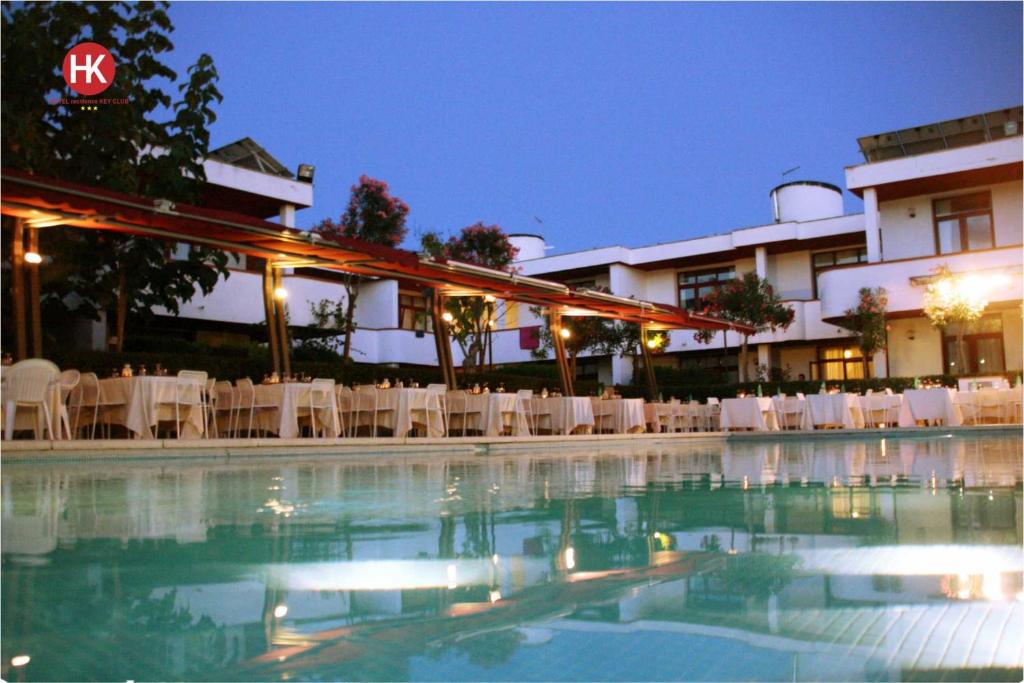 une piscine devant un hôtel la nuit dans l'établissement Hotel Residence Key Club, à Montalto di Castro