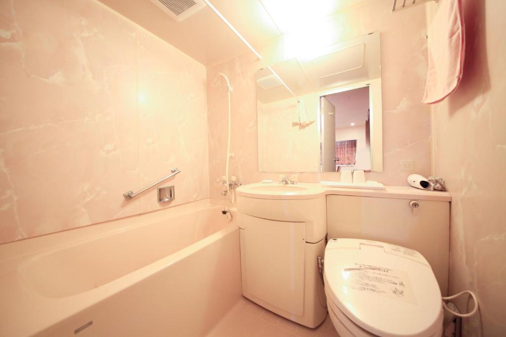 une salle de bain blanche avec des toilettes et un lavabo dans l'établissement Heiseikan Shiosaitei, à Hakodate