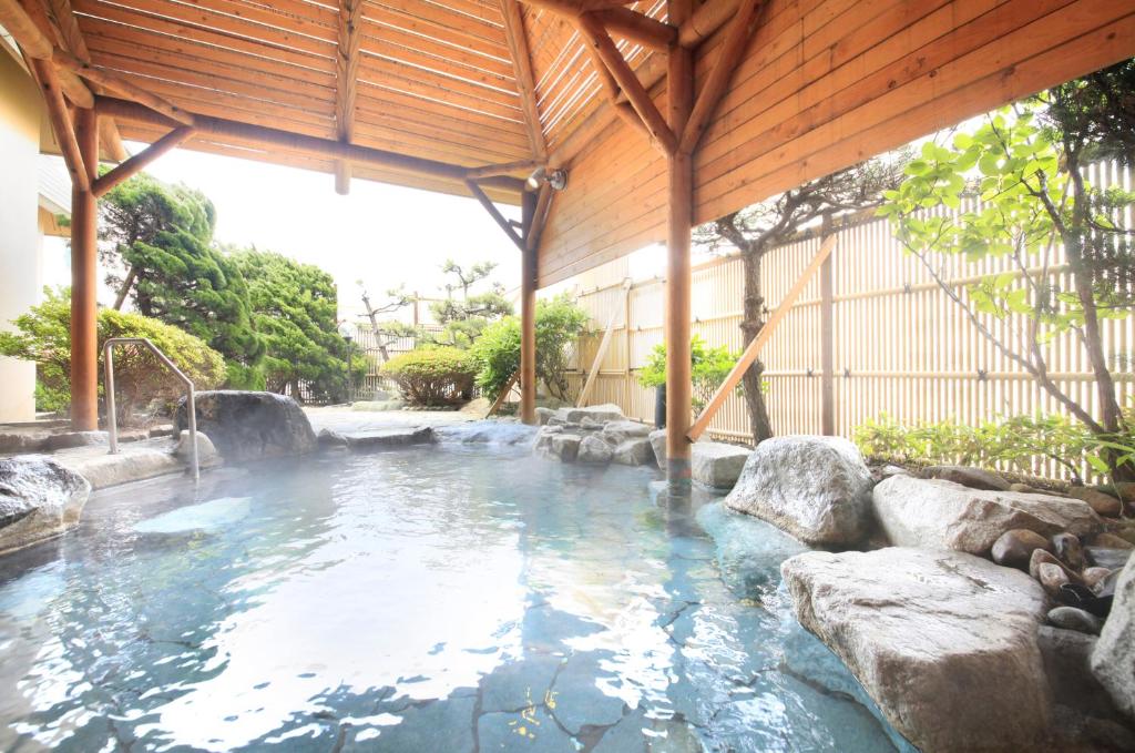 - une piscine avec des rochers dans l'eau dans l'établissement Heiseikan Shiosaitei, à Hakodate