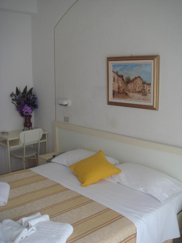 une chambre avec un lit et un tableau au mur dans l'établissement Hotel Arcade, à Rimini