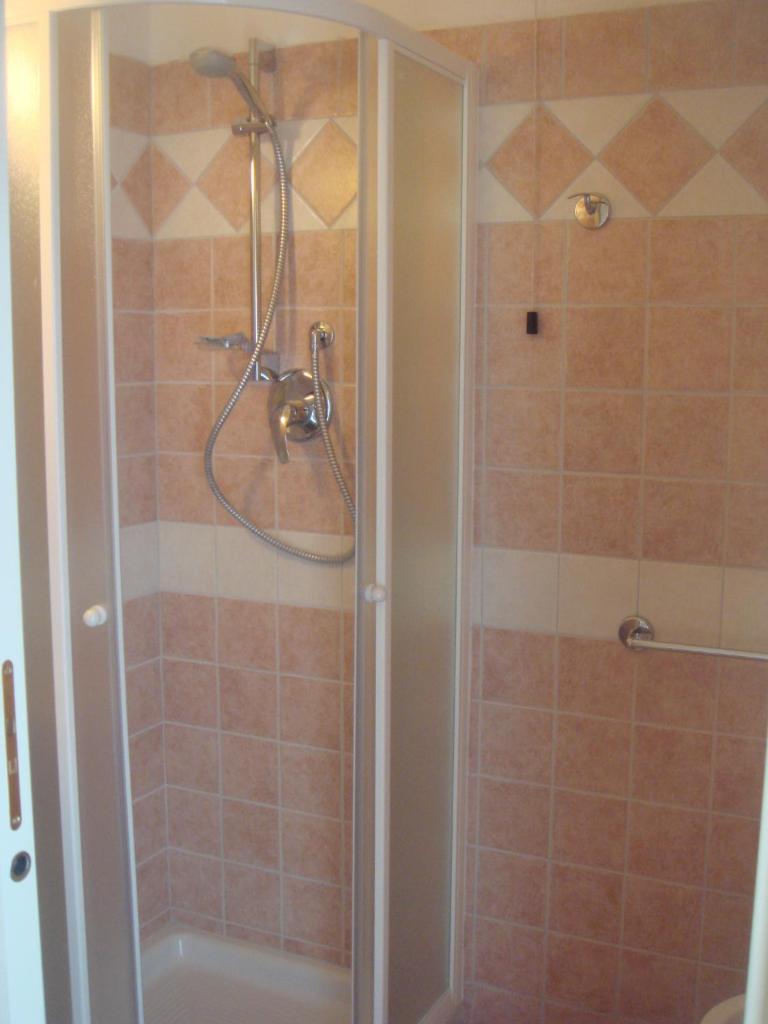 une douche avec une porte vitrée dans une salle de bain dans l'établissement Hotel Arcade, à Rimini