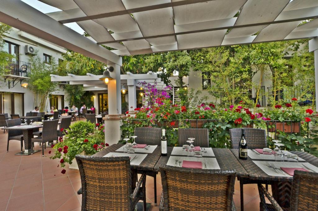 un restaurant avec des tables, des chaises et des fleurs dans l'établissement Hotel Santa Maria, à Santa Maria Navarrese