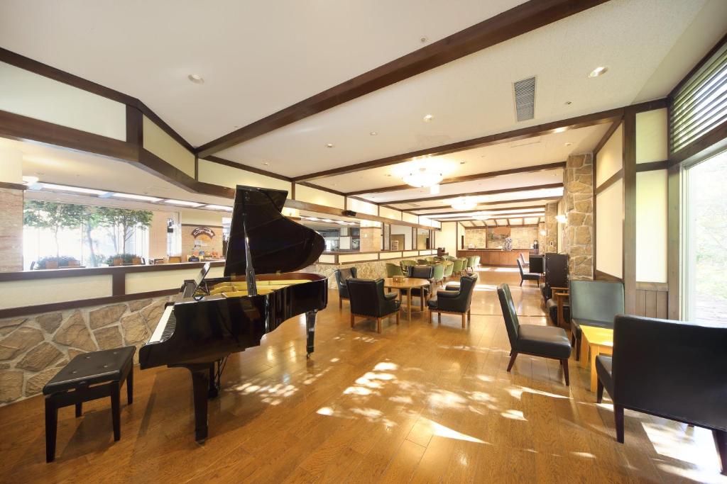 un restaurant avec un piano, des chaises et un bar dans l'établissement Choyo Resort Hotel, à Kamikawa