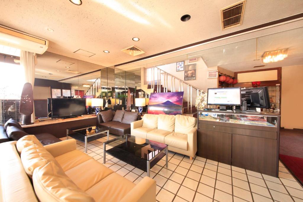 un salon avec un canapé et une télévision dans l'établissement Fujinomiya Green Hotel, à Fujinomiya