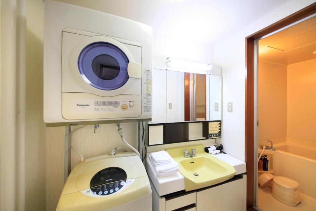 une salle de bain avec une machine à laver et un lavabo dans l'établissement Fujinomiya Green Hotel, à Fujinomiya