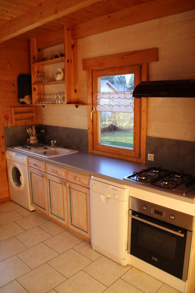 une cuisine avec une cuisinière et un évier dans l'établissement chalets de combebelle, à Saint-Léger-les-Mélèzes