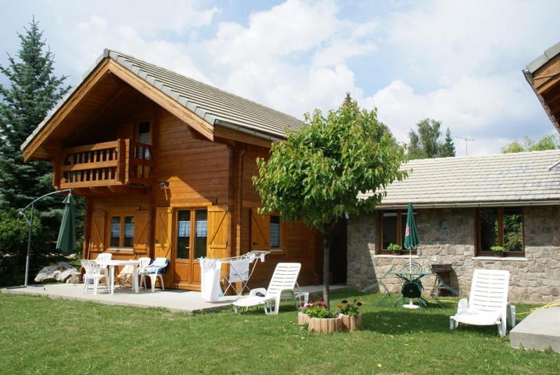 une cabane en rondins avec une table et des chaises dans la cour dans l'établissement chalets de combebelle, à Saint-Léger-les-Mélèzes