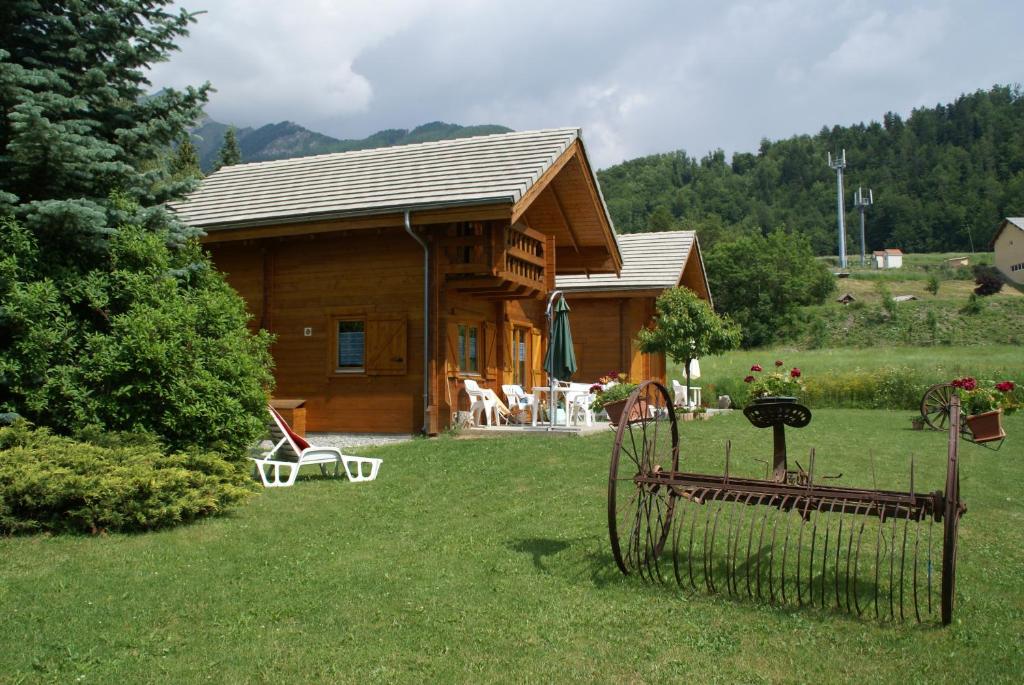 une cabane en rondins avec un portail dans la cour dans l'établissement chalets de combebelle, à Saint-Léger-les-Mélèzes