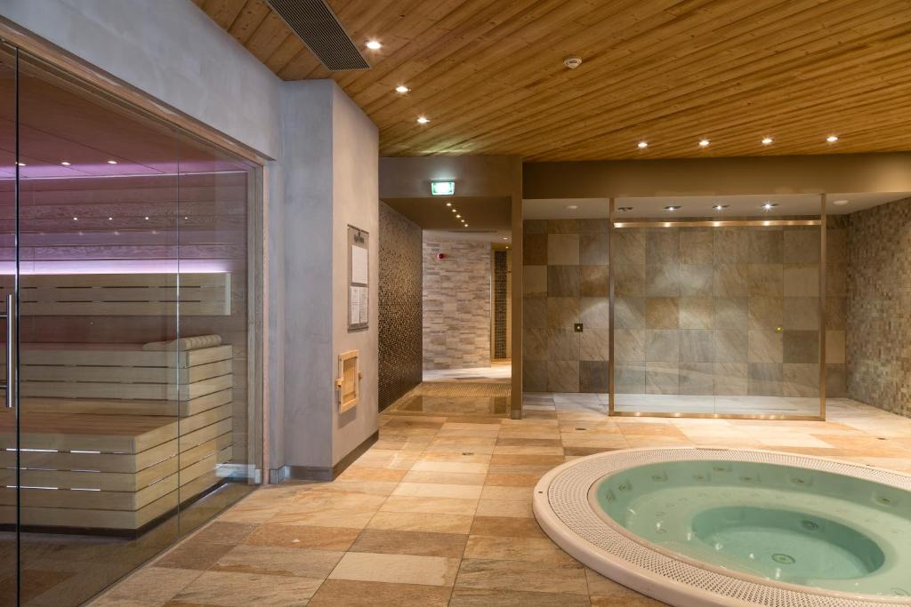 La grande salle de bains est pourvue d'un bain à remous et d'une douche en verre. dans l'établissement Hôtel Koh-I Nor by Les Etincelles, à Val Thorens