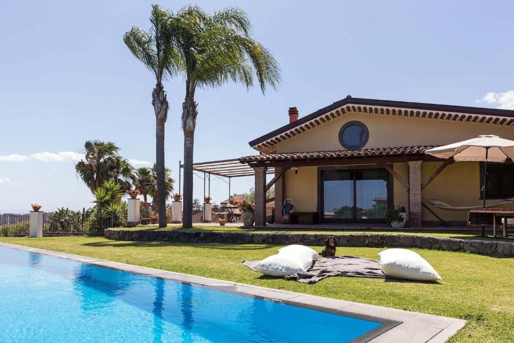 une maison avec deux grands oreillers à côté d'une piscine dans l'établissement Casa Dimora Vittoria, à Catane