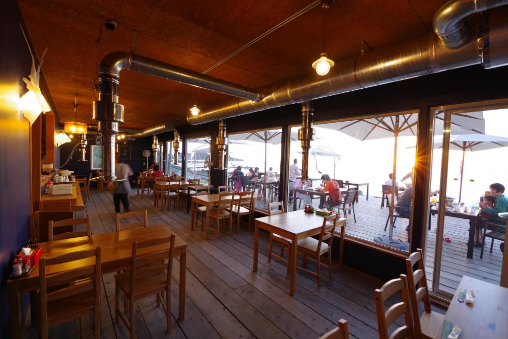 un restaurant avec des tables et des chaises et des gens sur une terrasse dans l'établissement SHIRETOKO Kokun Kekun, à Shari