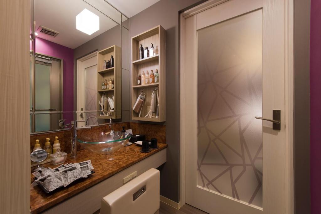 une salle de bain avec un lavabo et un miroir dans l'établissement Hotel Zen Rikyu Yokohama Hazawa, à Yokohama