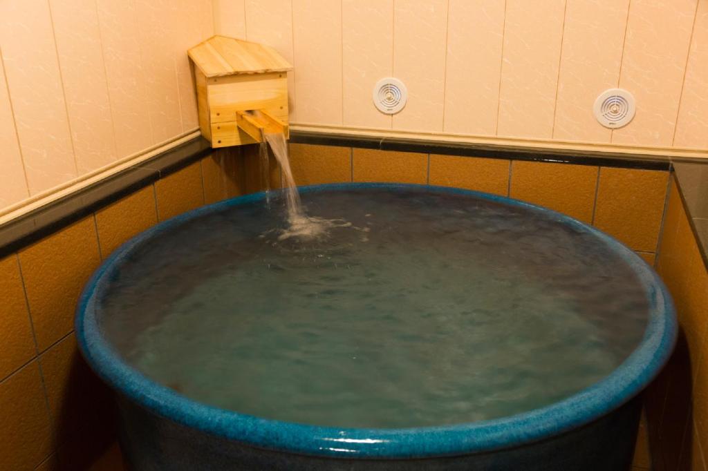 - un seau d'eau dans la salle de bains pourvue d'une fontaine dans l'établissement Hanaingen, à Kusatsu