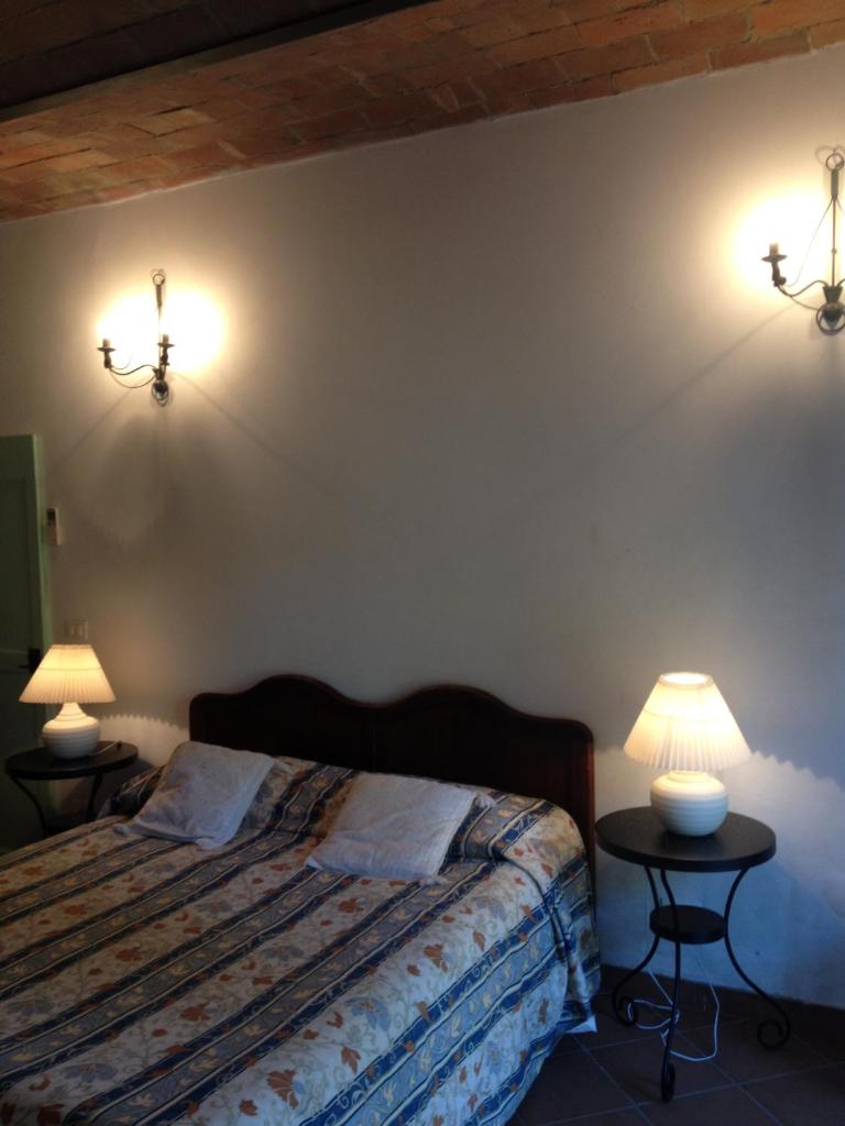 - une chambre avec un lit et 2 tables avec des lampes dans l'établissement La Toscanella, à Castagneto Carducci