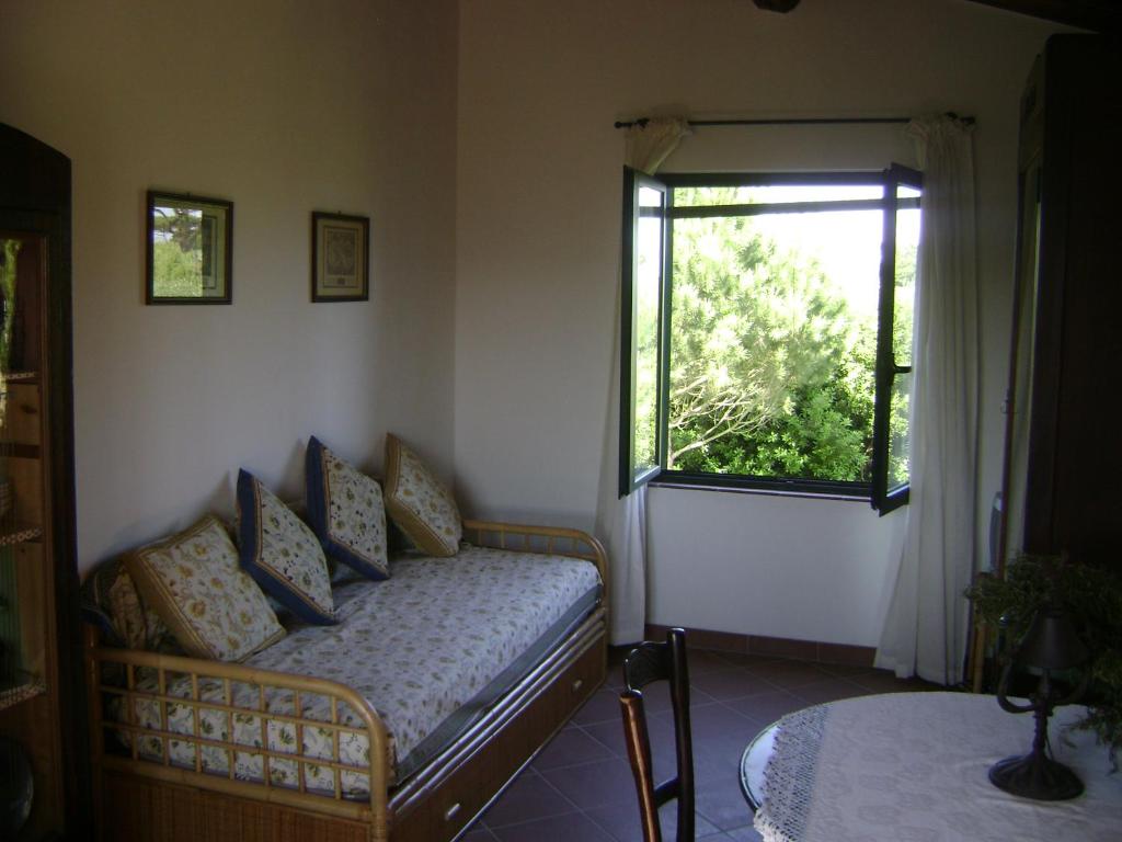 une chambre avec un lit et une fenêtre dans l'établissement La Toscanella, à Castagneto Carducci