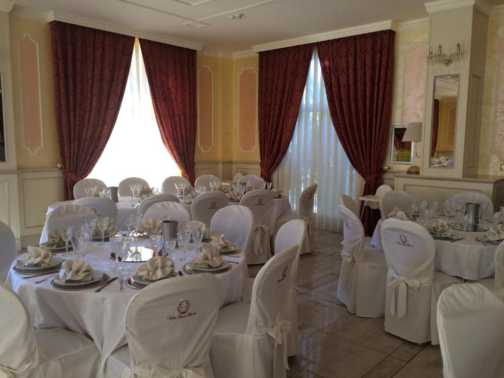 une salle remplie de tables et de chaises avec des nappes blanches dans l'établissement Hotel Villa Santa Maria, à Villapiana 23 autres photos