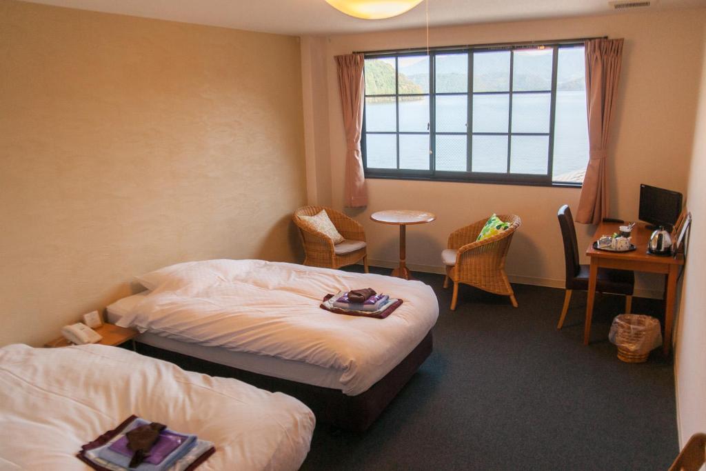 une chambre d'hôtel avec deux lits et une fenêtre dans l'établissement 湖上館パムコ, à Wakasa 37 autres photos