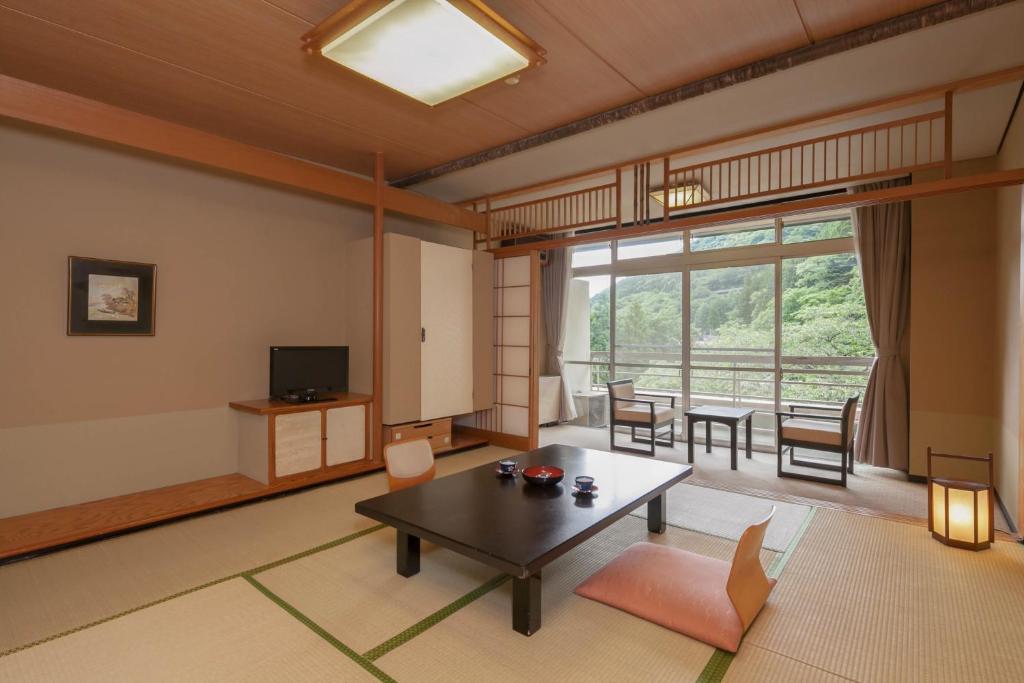 un salon avec une table et une salle à manger dans l'établissement Shima Grand Hotel, à Nakanojo