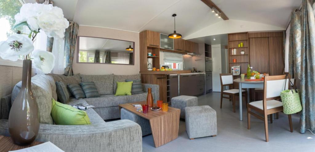 un salon avec un canapé et une table dans l'établissement Camping Officiel Siblu Les Dunes de Contis, à Saint-Julien-en-Born