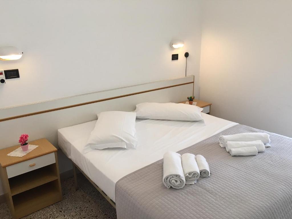 une chambre avec deux lits avec des serviettes dessus dans l'établissement Hotel Glenn, à Rimini