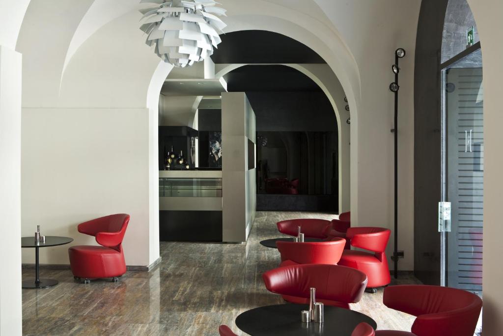 - un hall avec des chaises rouges et un lustre dans l'établissement Hotel Romano House, à Catane