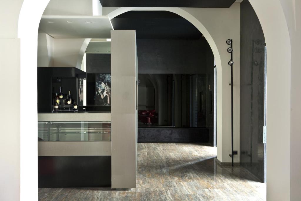 une voûte menant à une chambre avec une cuisine dans l'établissement Hotel Romano House, à Catane