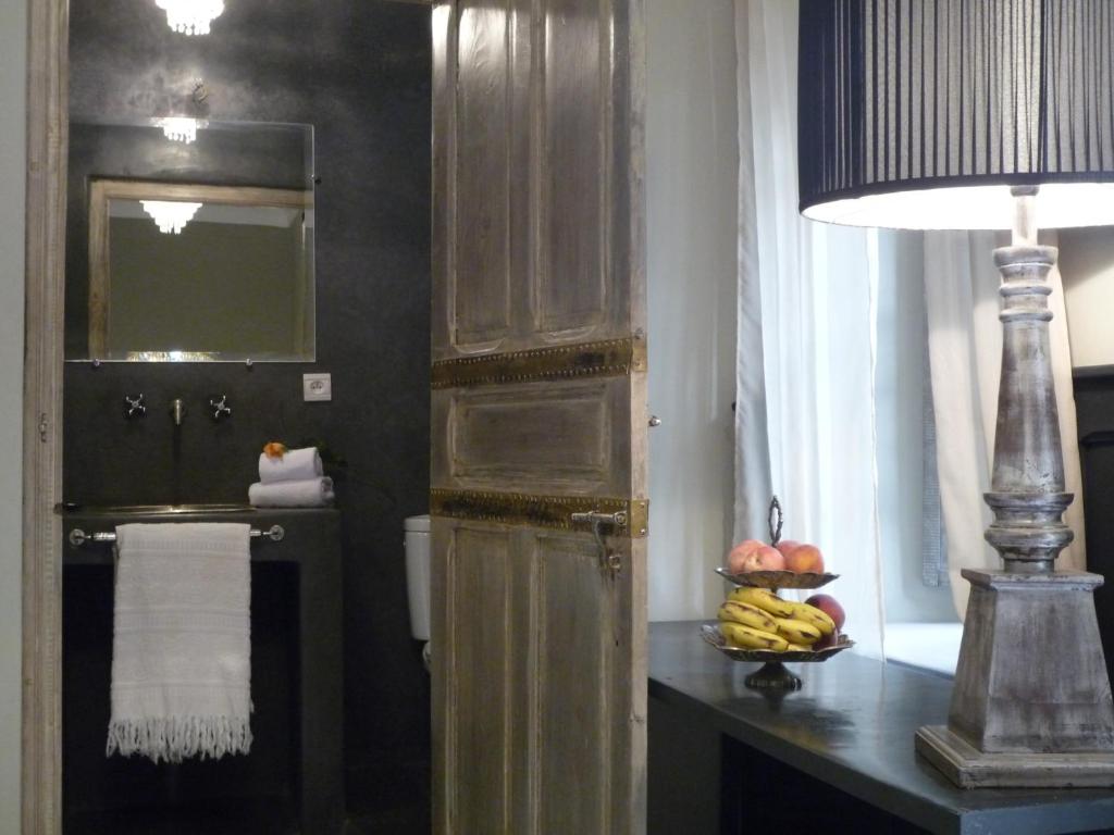 - une salle de bains pourvue d'une table avec une lampe et un bol de fruits dans l'établissement Dar al Sultan, à Marrakech