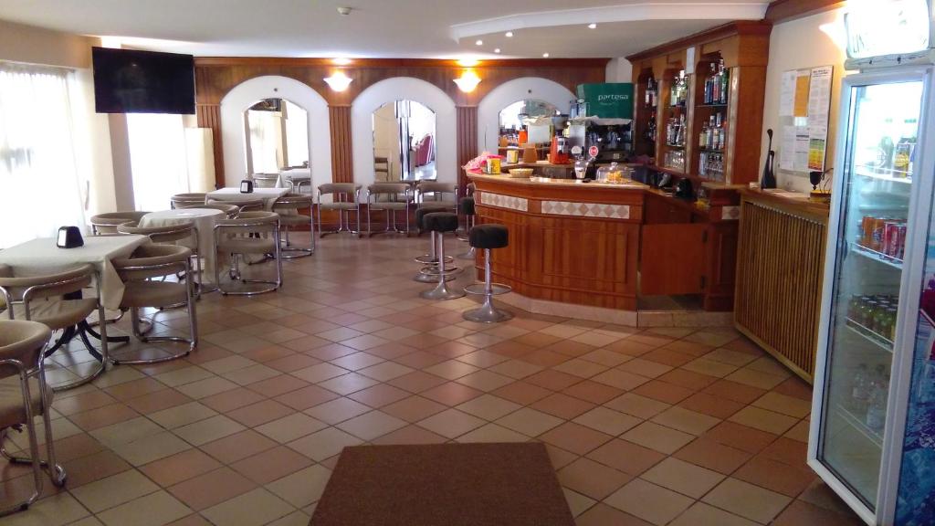 un restaurant avec un bar, des tables et des chaises dans l'établissement Hotel Glenn, à Rimini