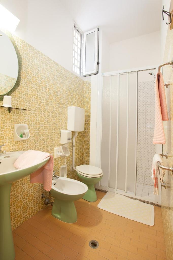 La salle de bains est pourvue de 2 toilettes, d'un lavabo et d'une douche. dans l'établissement Hotel Palazzi, à Gabicce Mare