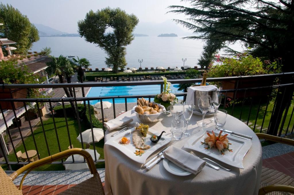 une table avec une assiette de nourriture sur un balcon dans l'établissement Grand Hotel Dino, à Baveno