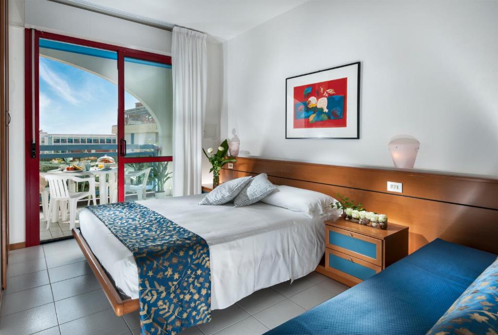 une chambre avec un lit et un balcon dans l'établissement Princess Aparthotel, à Bibione