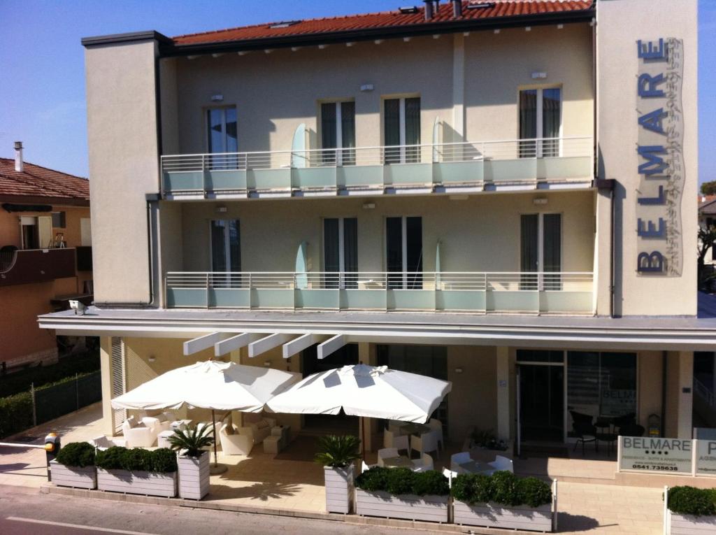 un hôtel avec des parasols en face dans l'établissement Residence Belmare, à Rimini