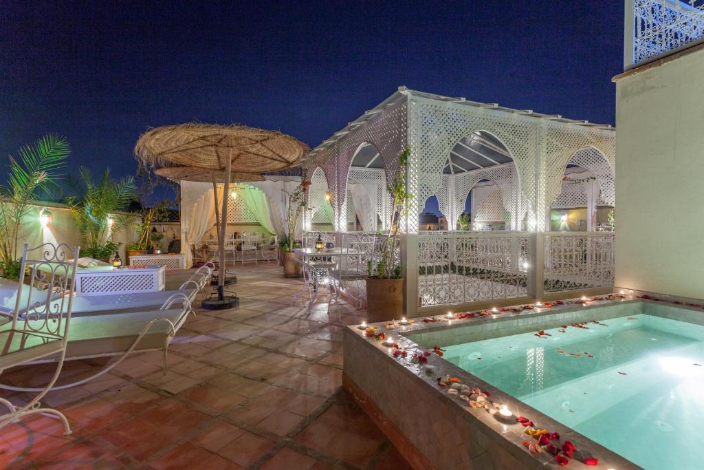 - une piscine dans un complexe la nuit dans l'établissement Astra Damus Hotel, à Marrakech