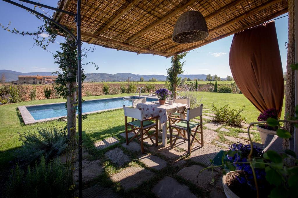 un patio avec une table et des chaises et une piscine dans l'établissement Villa Il Nido, à Cortone